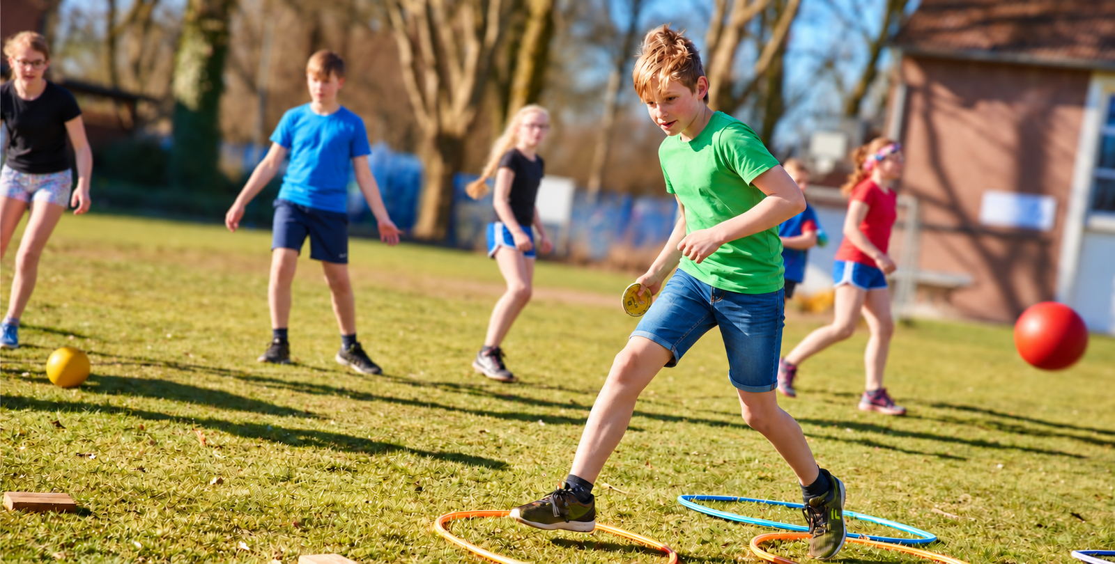 Kinder spielen auf der Wiese ein Spiel mit Ringen