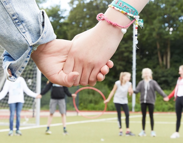 Kinder spielen auf der Wiese ein Spiel mit Ringen